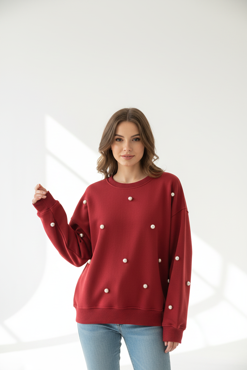 Model draagt rode oversized sweater Gimme met gouden parel studs