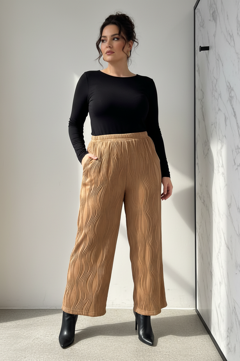 Model draagt de camel plus size Broek Times met golvende reliëf textuur in een luxe editorial setting