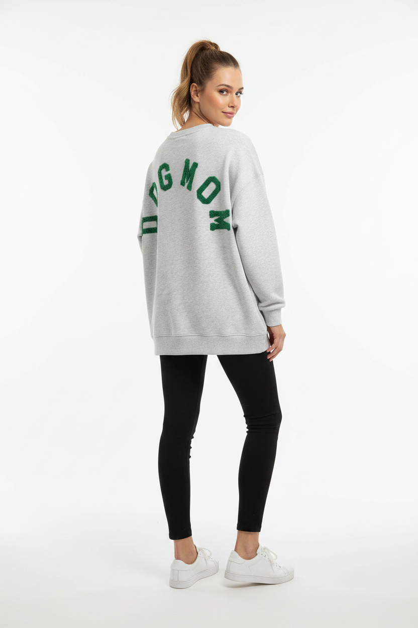 Model draagt het DOGMOM Oversized Sweatshirt in grijs melange met groen geborduurd logo op de rug