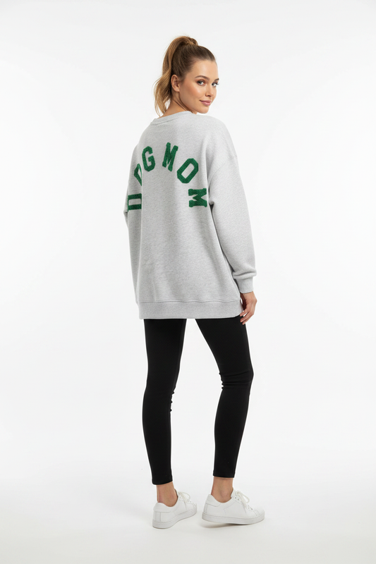 Model draagt het DOGMOM Oversized Sweatshirt in grijs melange met groen geborduurd logo op de rug