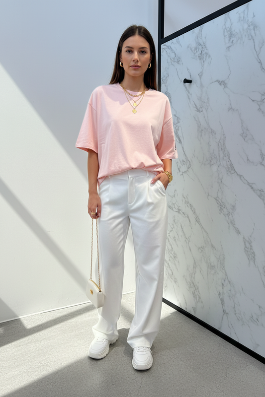 Model in T-shirt Gimme Paris zacht roze oversized — editorial stijl