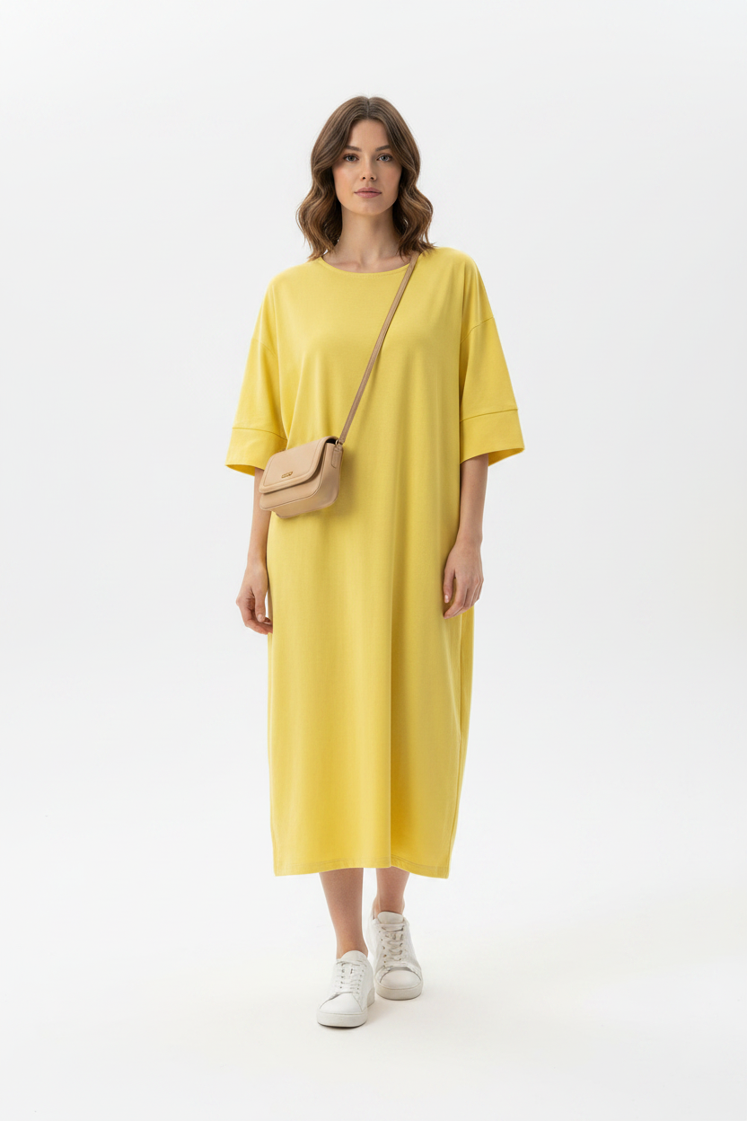 Model in helder geel oversized t-shirt midi-jurk Just Woman, gestileerd met witte sneakers