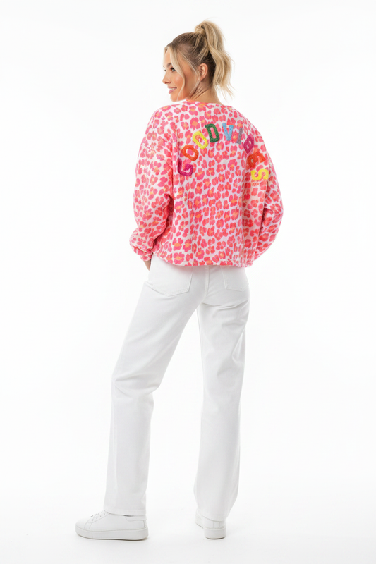 Model draagt het GOODVIBES Oversized Sweatshirt in panther roze met kleurrijk geborduurd logo op de rug