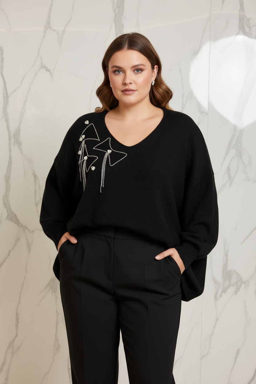 Model draagt de zwarte plus size Trui Times met kristallen strikjes in een luxe editorial setting