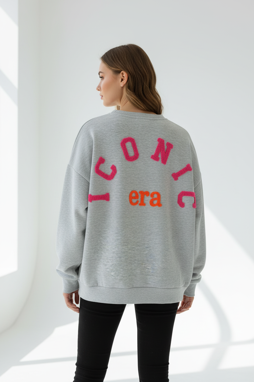 Model draagt grijze oversized sweatshirt ICONIC era van achteren