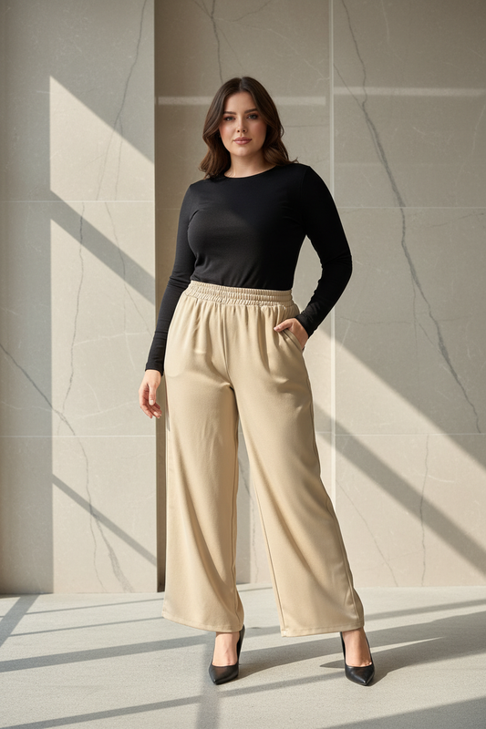 Model draagt de beige plus size satijn wide-leg Broek Times in een luxe editorial setting