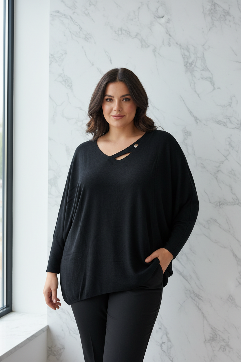 Model draagt de zwarte plus size Trui Times met diepe V-hals en gekruiste banden in een luxe editorial setting
