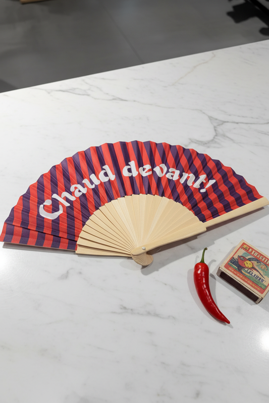 Rood-paarse gestreepte waaier Chaud devant! met witte vintage tekst en bamboe handvat